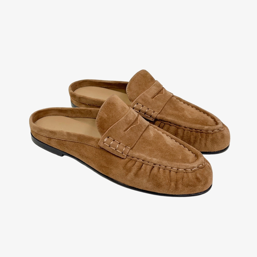 Bruin suède loafer muiltje voor dames, op een grijze achtergrond