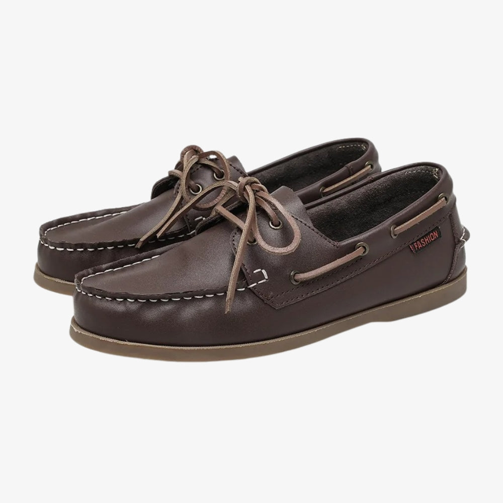 Boot loafers voor heren van bruin leer, op een grijze achtergrond