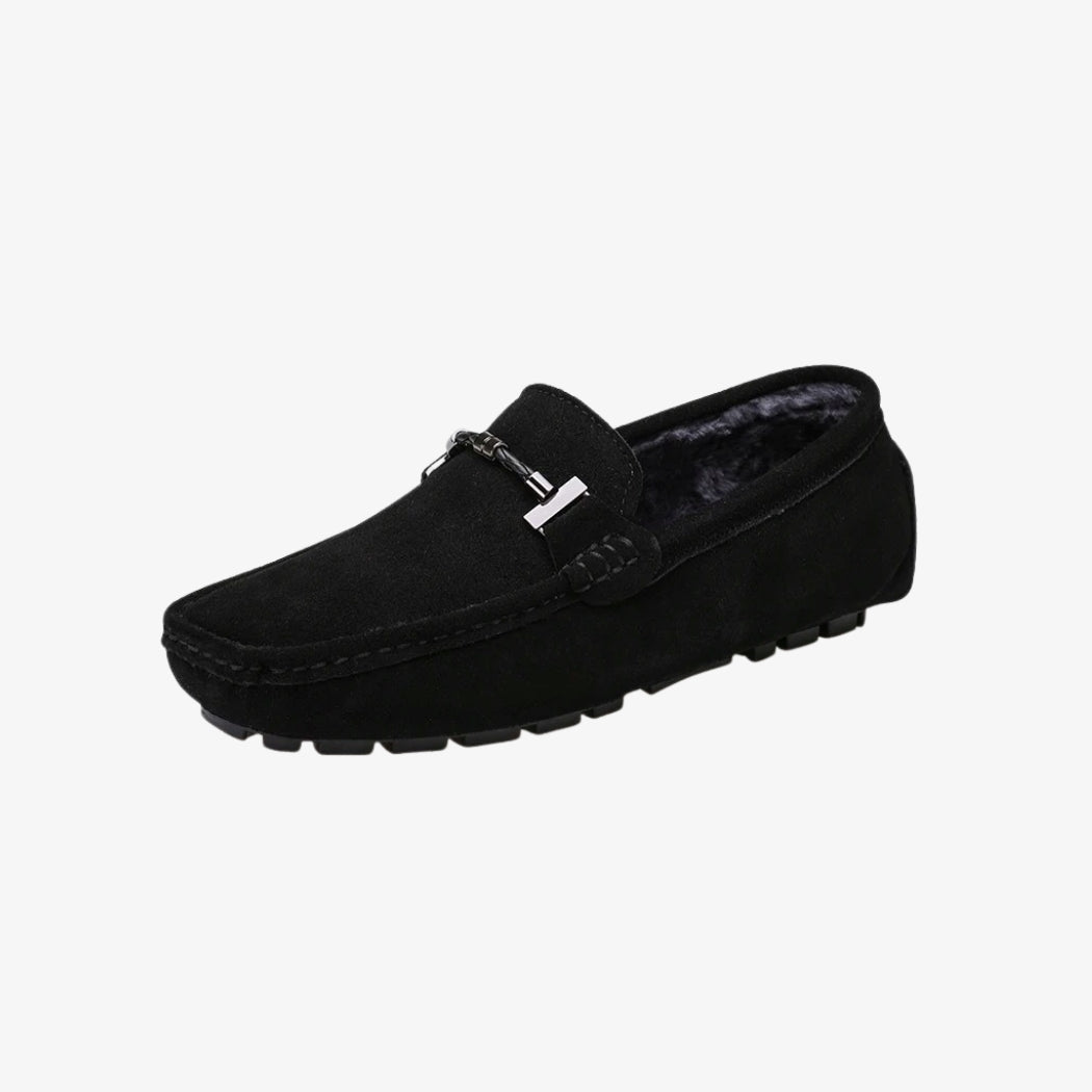 Loafers in zwart suède voor heren, gevoerd met zacht materiaal voor meer comfort. Het klassieke ontwerp wordt opgesmukt door een zilverkleurige metalen gesp op de bovenkant. De zool met profiel geeft goede grip en combineert stijl en functionaliteit.