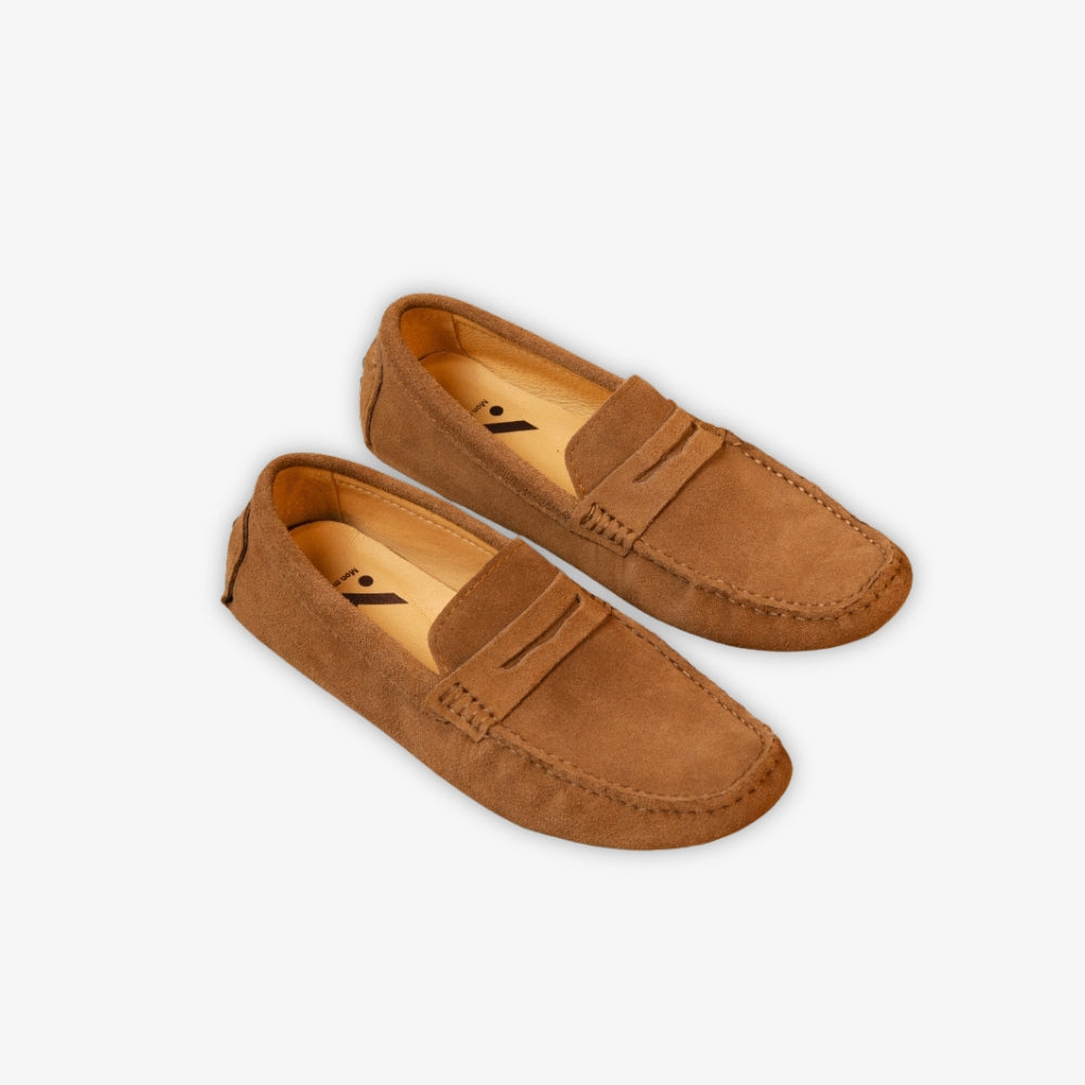 klassieke bruine loafer op de grond, tegen een beige achtergrond