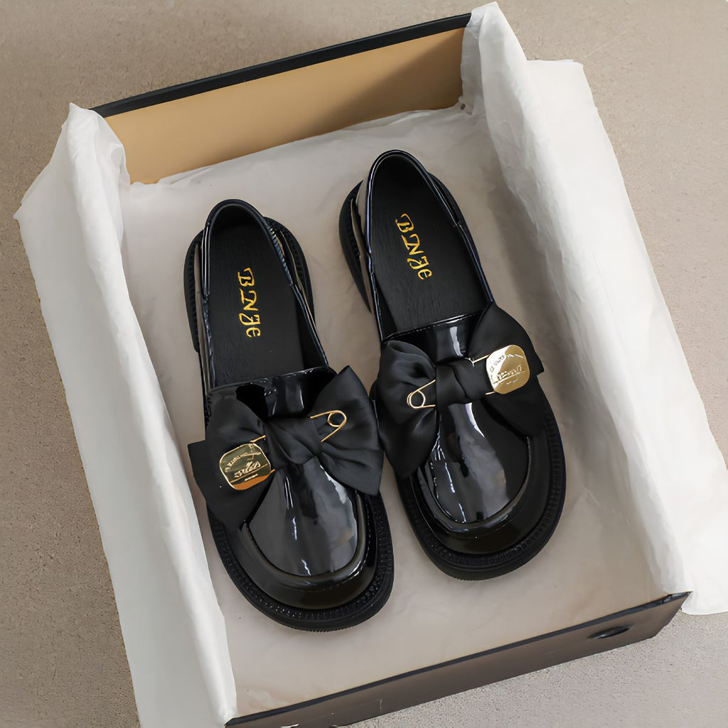 Mocassins met dikke zool, vlinderdas en speld
