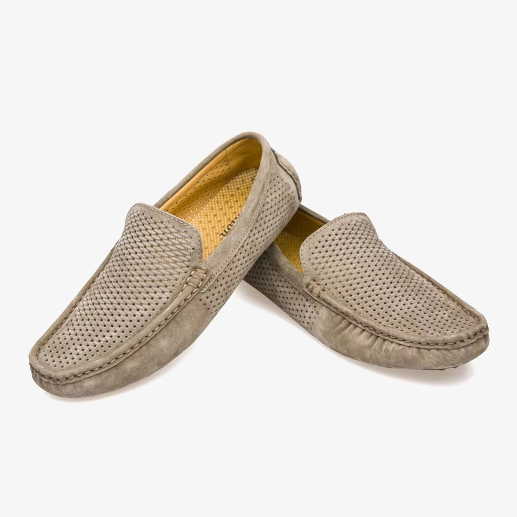 Een paar zomerse suède loafers voor heren op een witte achtergrond.