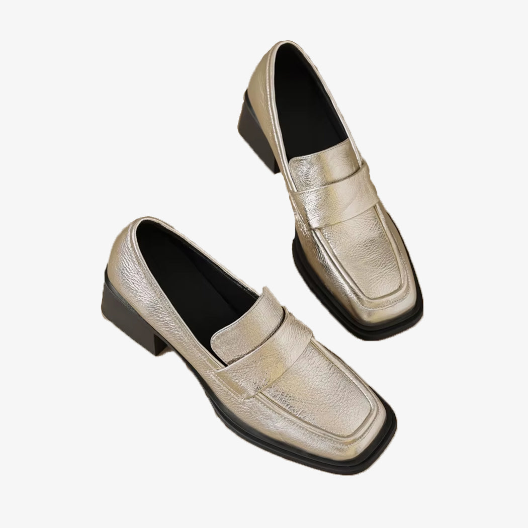 Gouden loafers met hak voor dames op een witte achtergrond