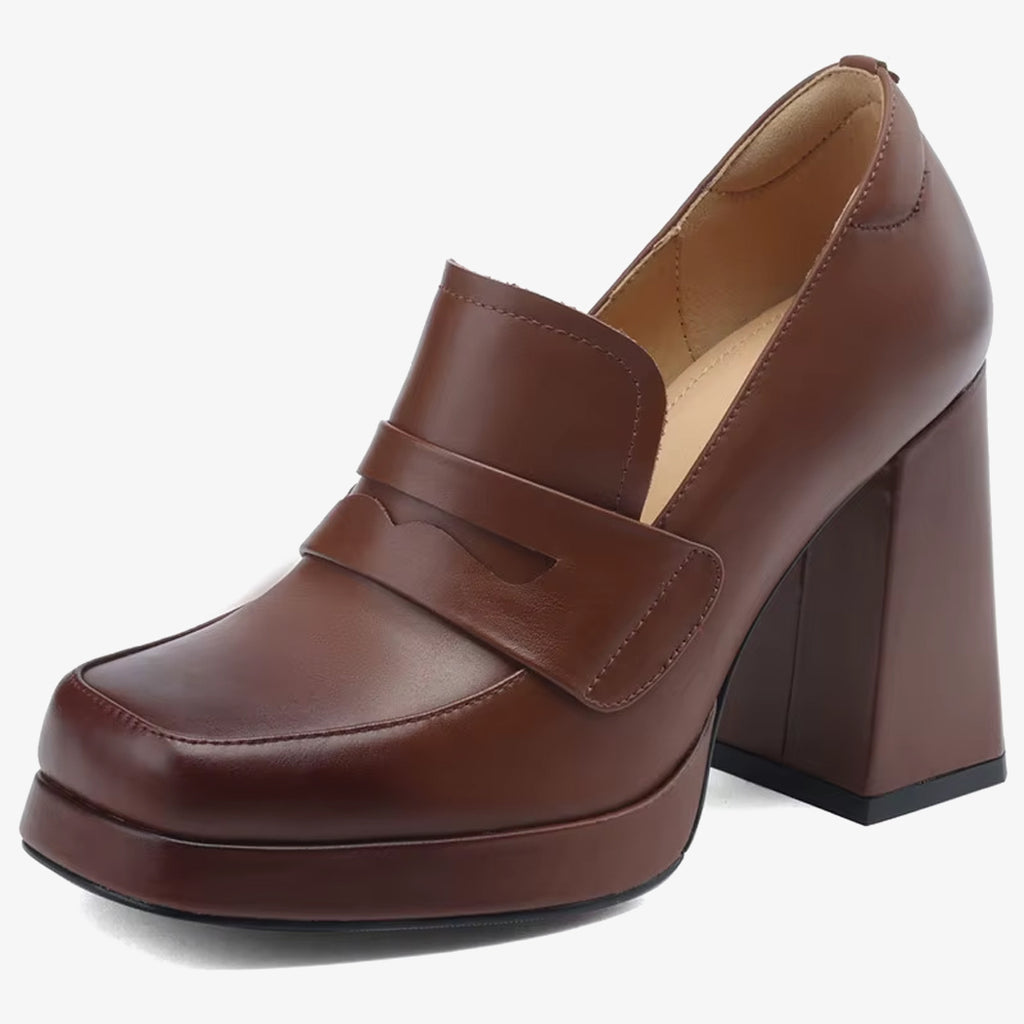 Een leren loafer met hak voor dames in bruin op een witte achtergrond