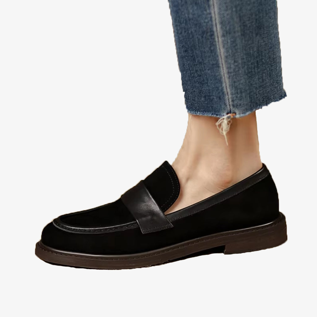 Foto van een klassieke zwarte suède loafer voor dames met bandje, gedragen met een jeans