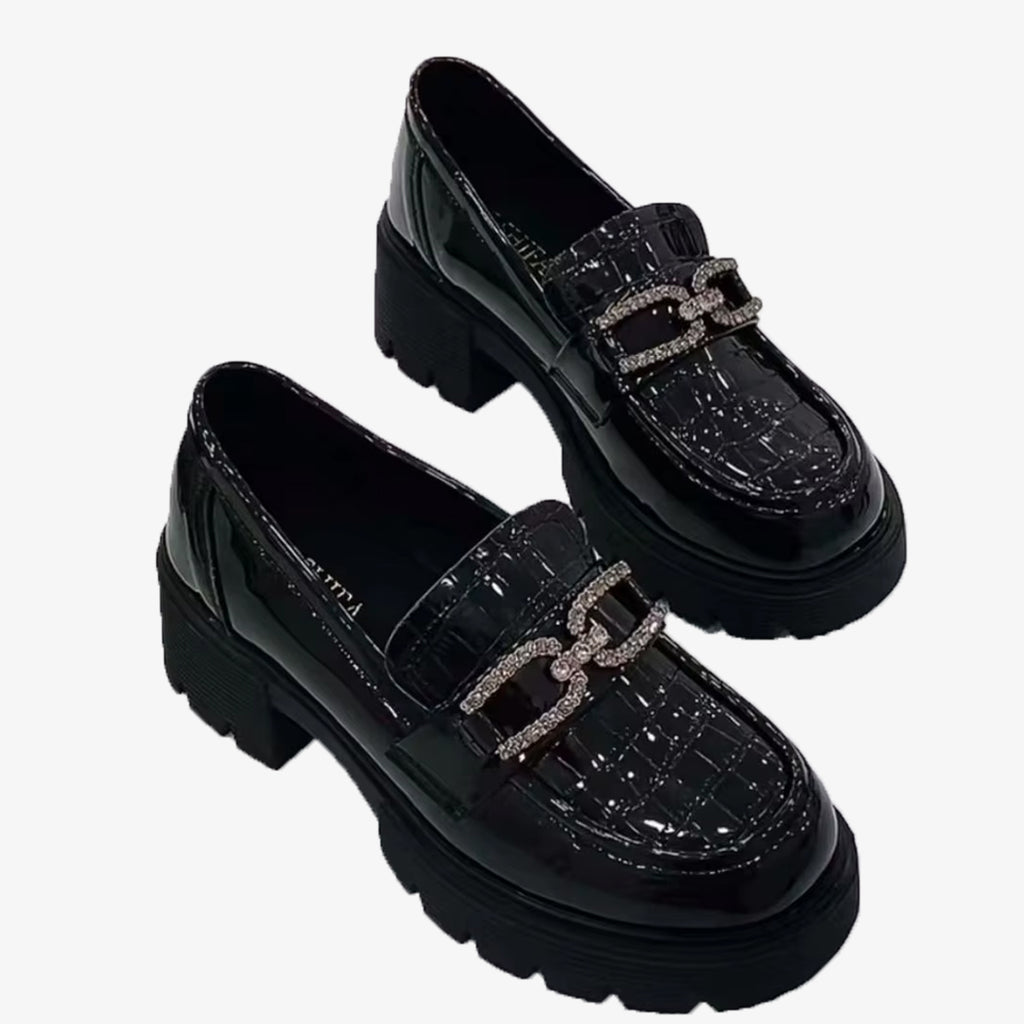 Zwarte plateauschoenen van suède met strass-ketting op een witte achtergrond