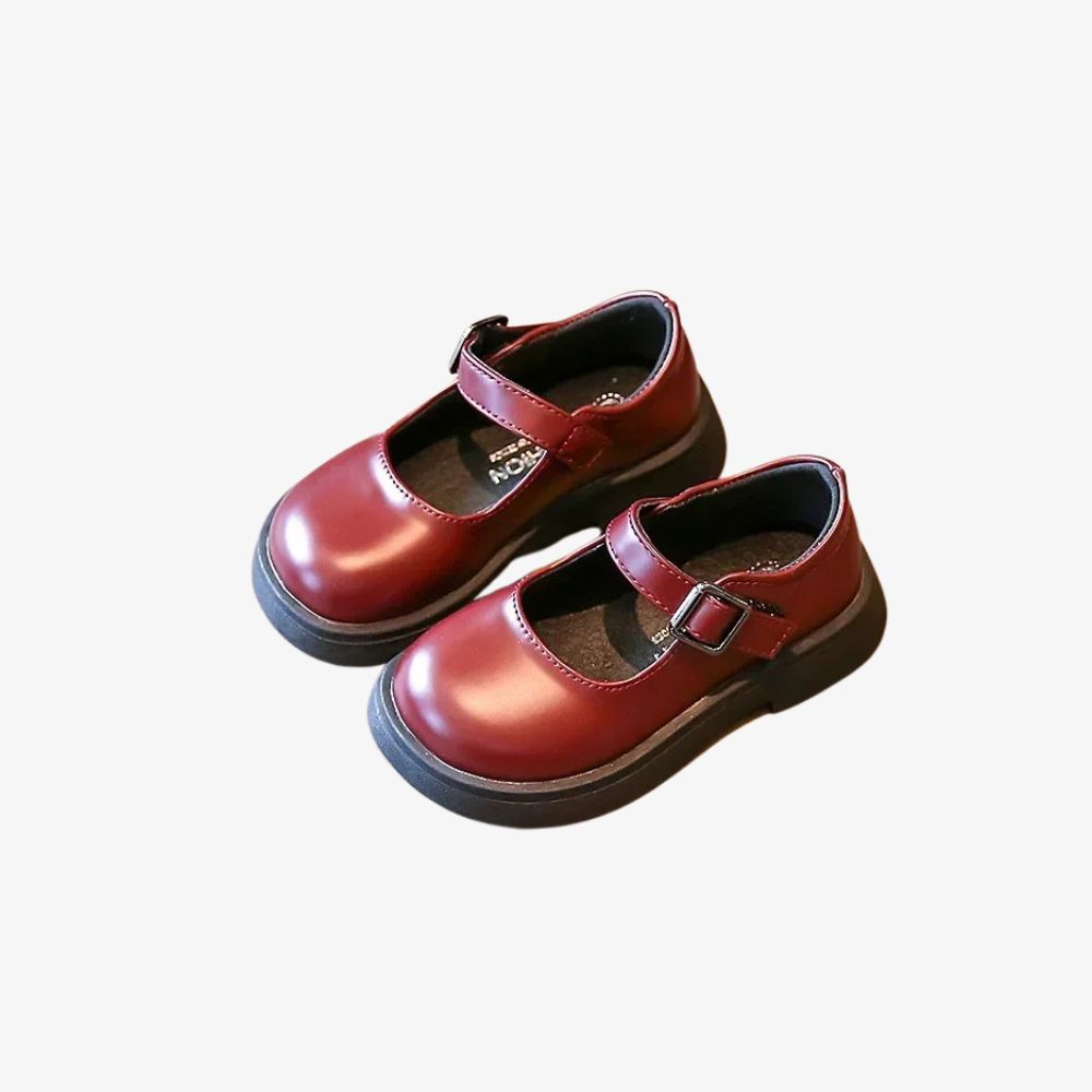 Paar bordeauxrode kinderloafers, met een bandje.