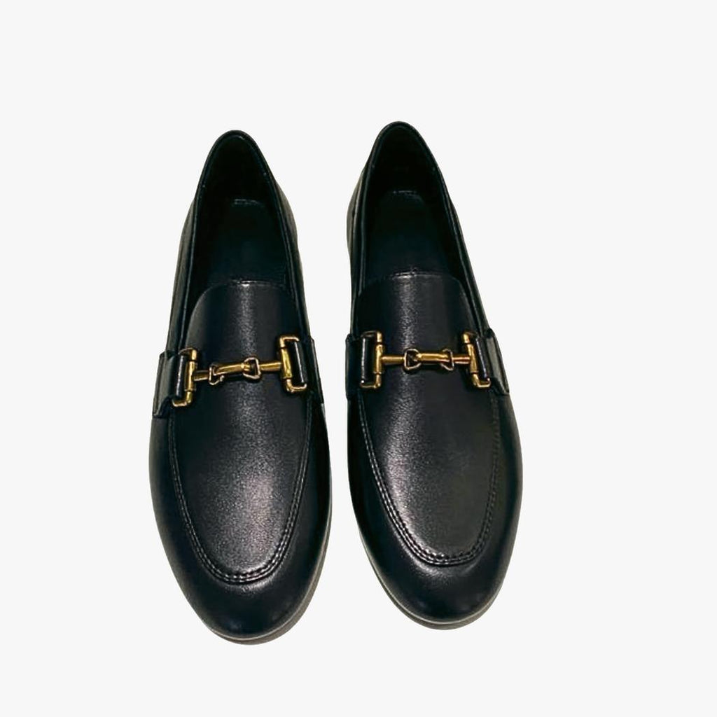 je ziet op een witte achtergrond een paar zwarte dames loafers van echt leer