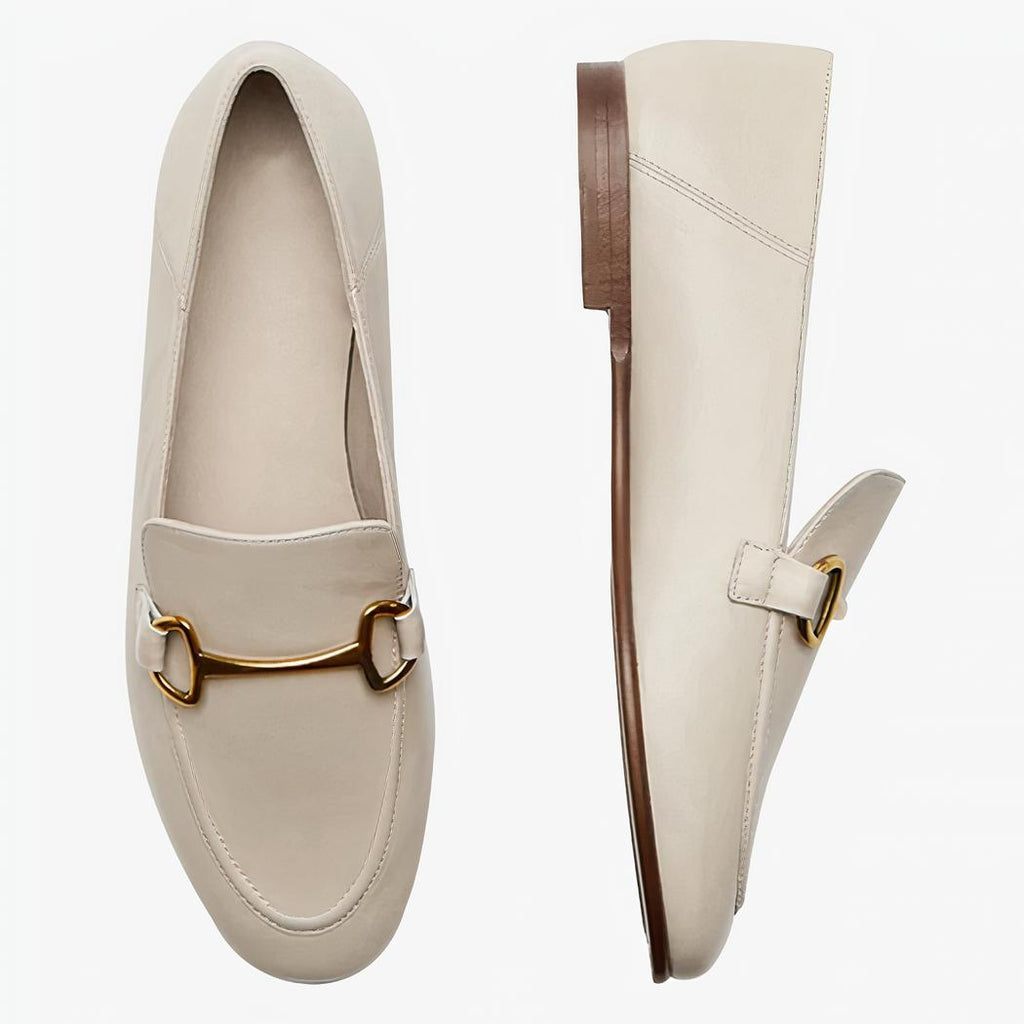 Op een lichte achtergrond zie je een paar beige dunne en lichte loafers in echt leer