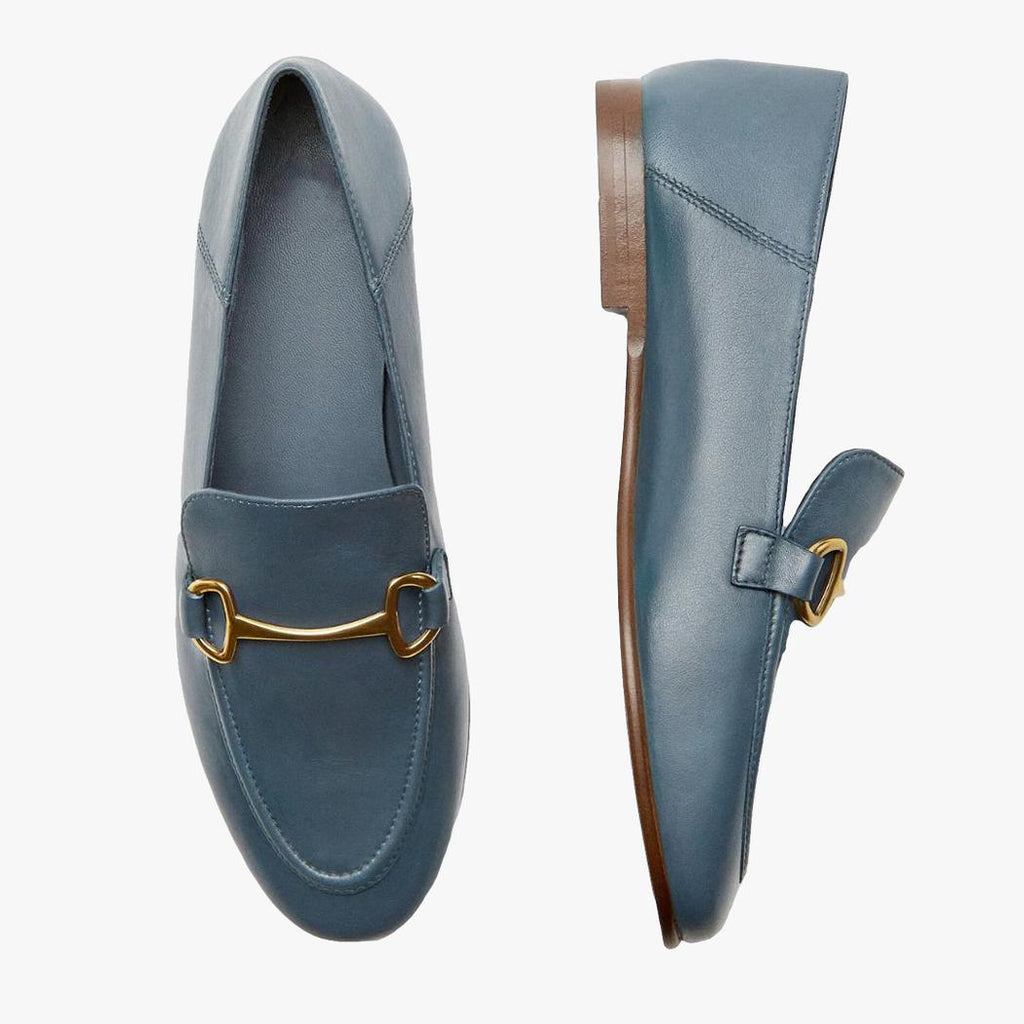 Op een lichte achtergrond zie je een paar blauwe dunne en lichte loafers in echt leer