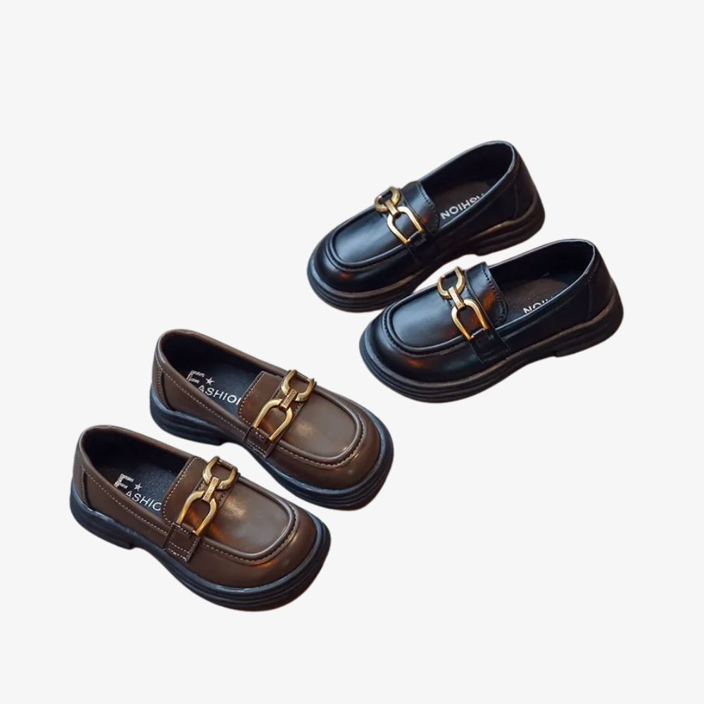 2 paar zwarte en bruine loafers met gespen, op een grijze achtergrond.