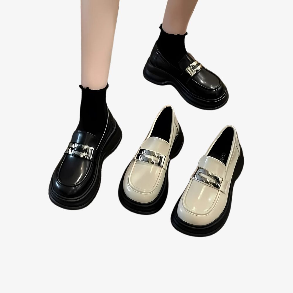 Damesbenen met zwarte plateauloafers, met daarnaast hetzelfde paar schoenen in beige