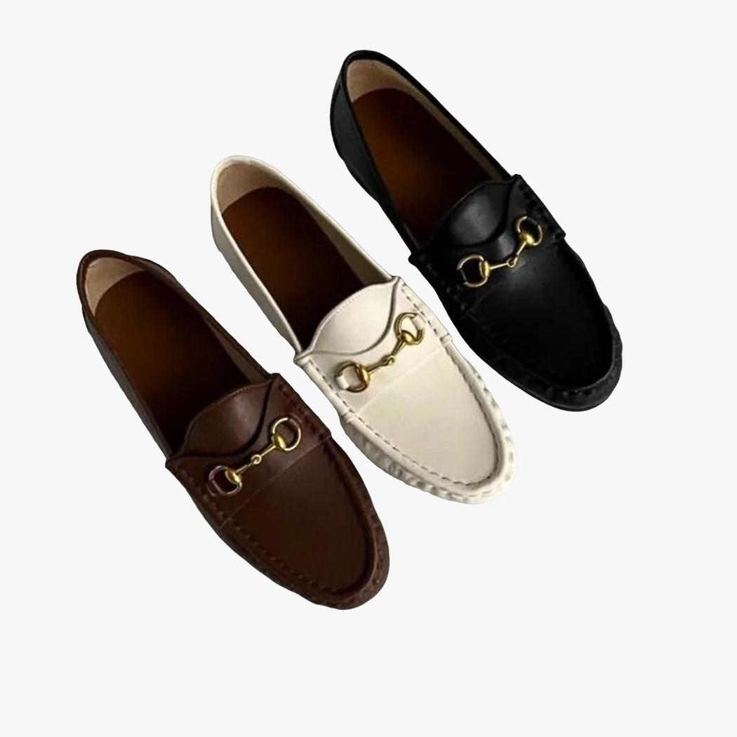 je ziet op een lichtgrijze achtergrond 3 zachte loafers van echt leer voor dames: een witte, een bruine en een zwarte.