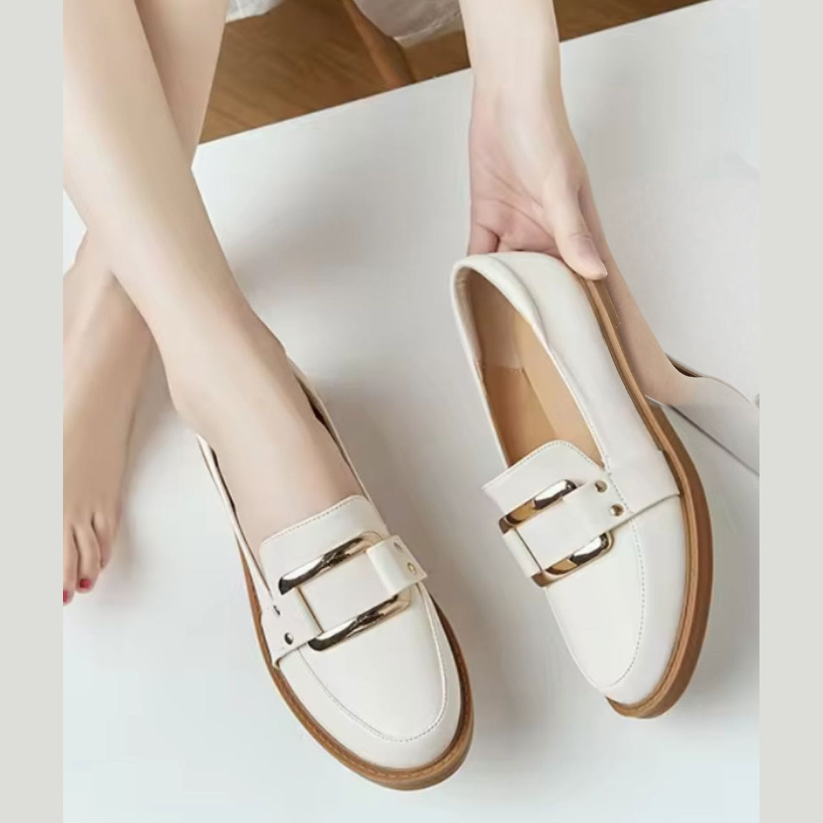 Beige mocassin met gouden gesp gedragen