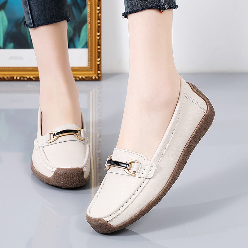Leren loafers met gouden details voor dames met een grijze achtergrond en een gouden paneel op de achterkant