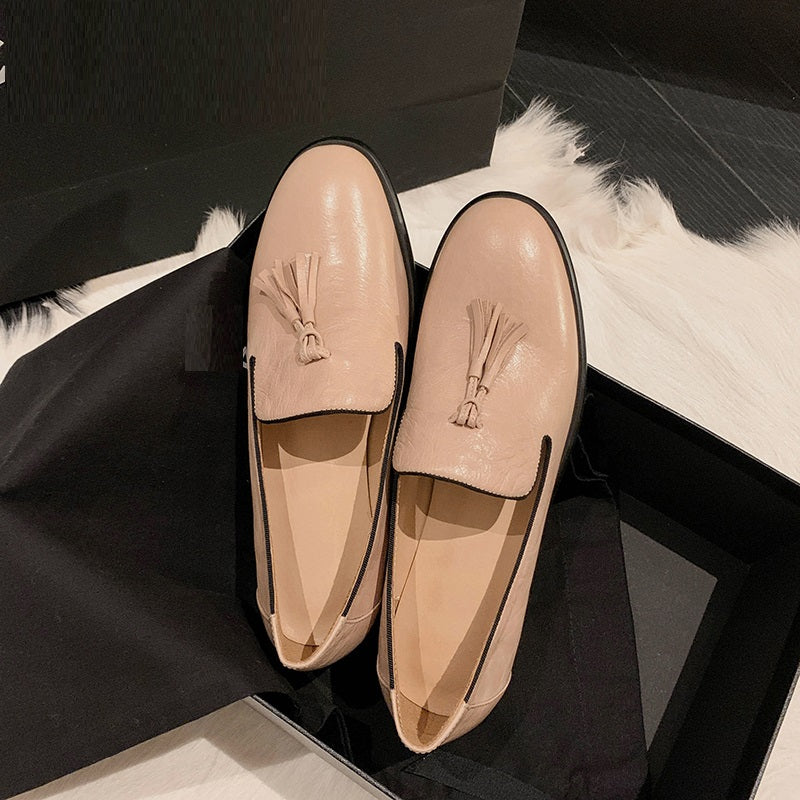 Paar roze leren loafers op een zwart element
