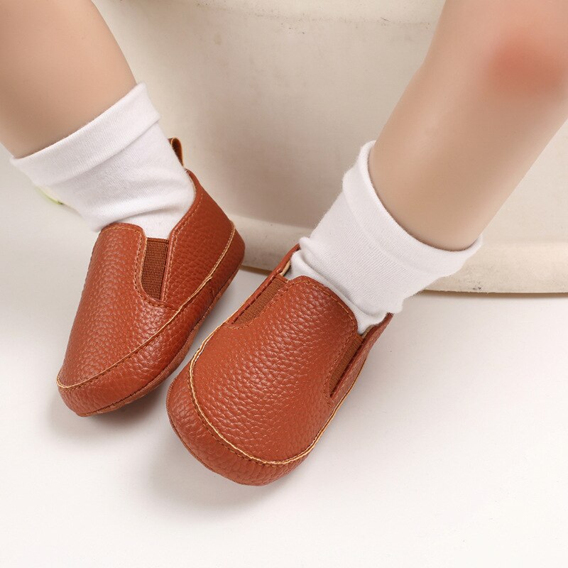 Baby met witte sokken en effen bruine mocassins van synthetisch leer
