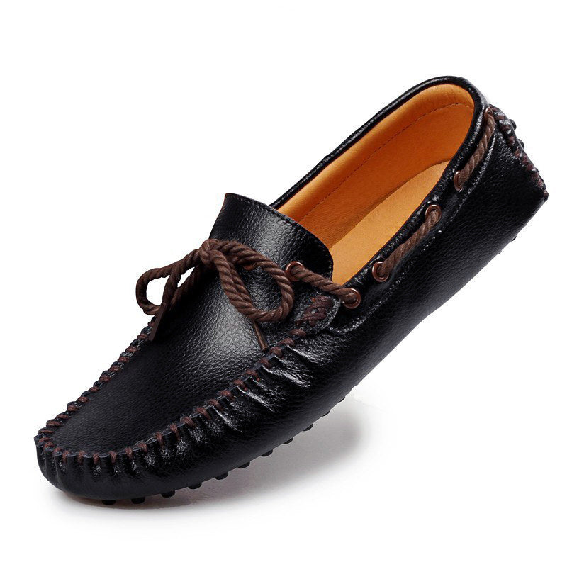 Zwarte mocassin met strik op witte achtergrond.