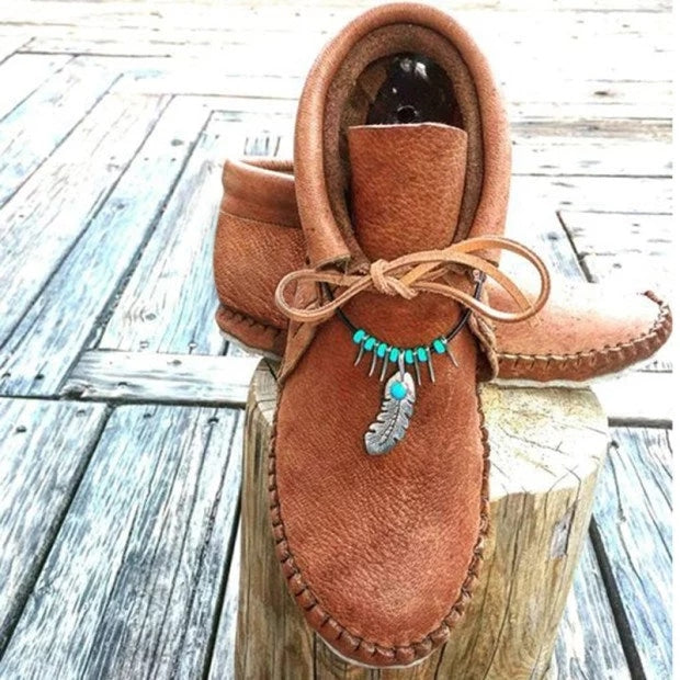 Hoge indianen mocassins met decoratieve veren