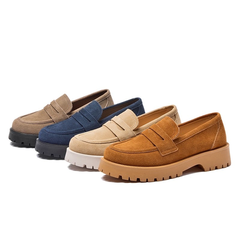 Vier eenvoudige suède loafers in verschillende kleuren, grijs-blauw-beige en bruin met dikke zolen op een witte achtergrond.