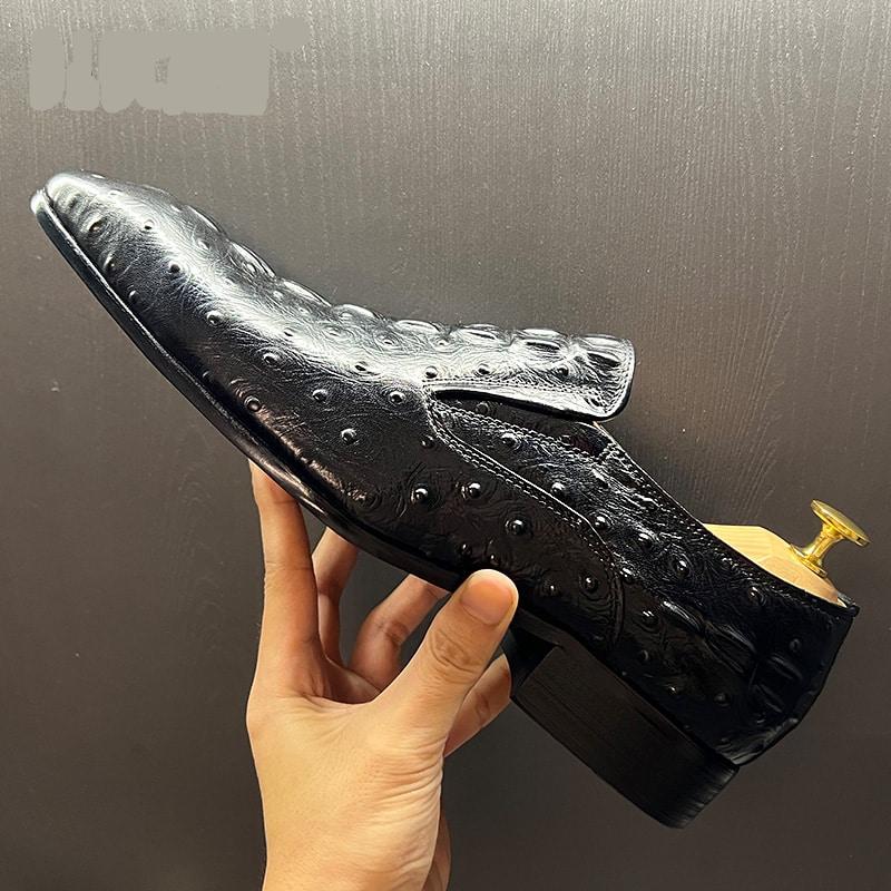 Eén persoon houdt een zwarte mocassin in de vorm van een krokodil vast met een schoenlepel erin