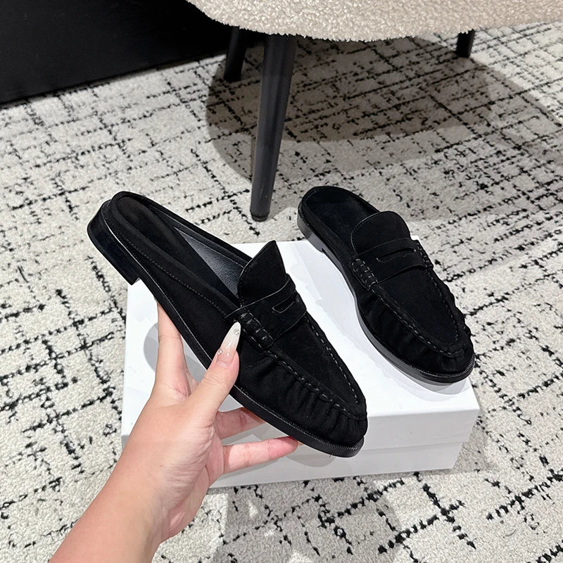 Loafer-mule dames leer platte hak in zwart suède, close-up van de afwerking