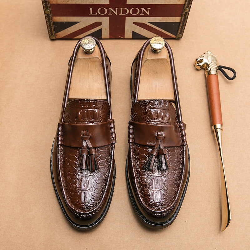 Bruine loafers met kwastjes op beige vloeren met een goudkleurige schoen ernaast
