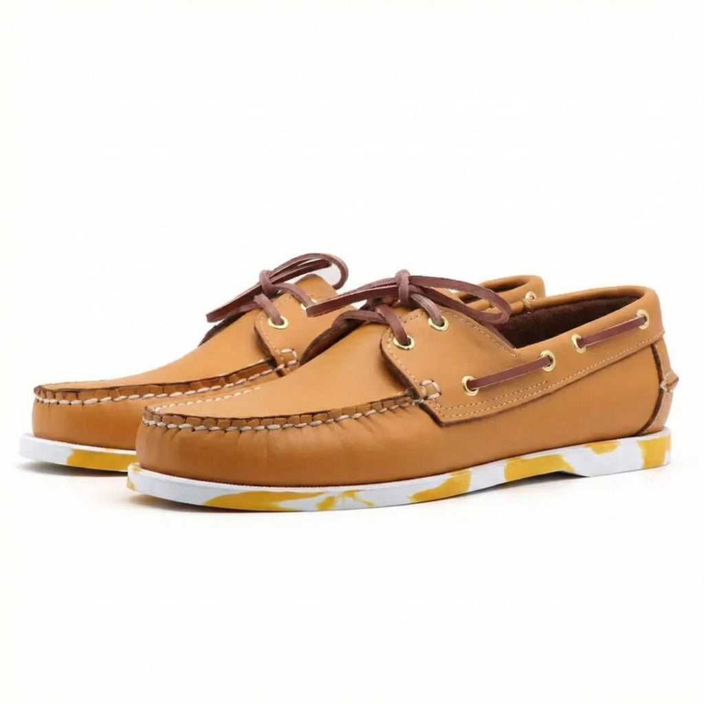 Paar camel bootsloafers van leer met gekleurde zool op witte achtergrond