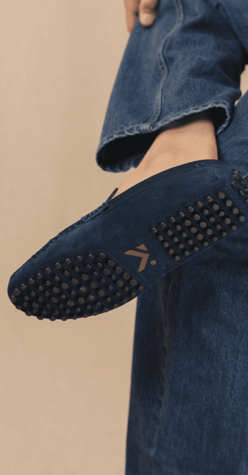 Detail van de noppenzool van een marineblauwe suede loafer