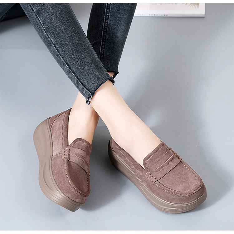 Paar orthopedische plateauzolen in beige suède met een rode en een zwarte loafer ernaast