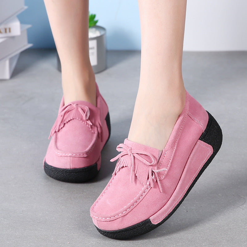 Voetjes met roze mocassins met franjes en strikje aan de voorkant