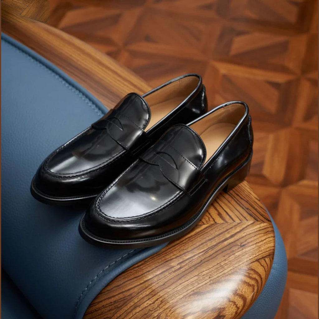 Penny loafers heren bruin suède in zwart, paar van opzij