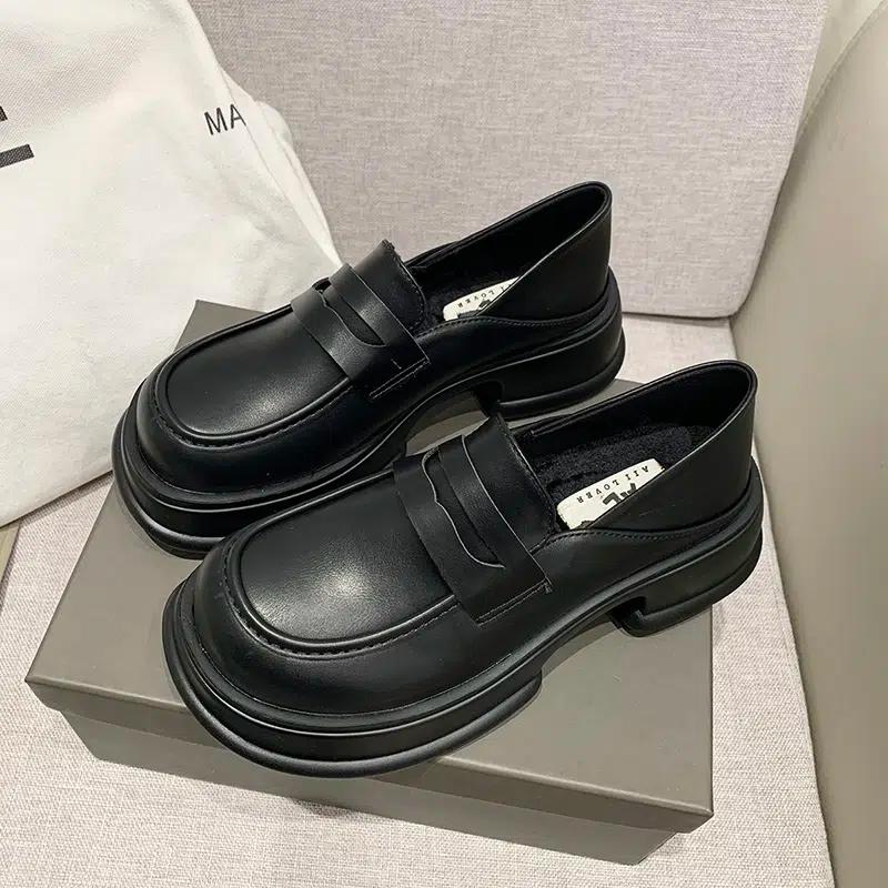 Twee zwarte mocassins op een doos