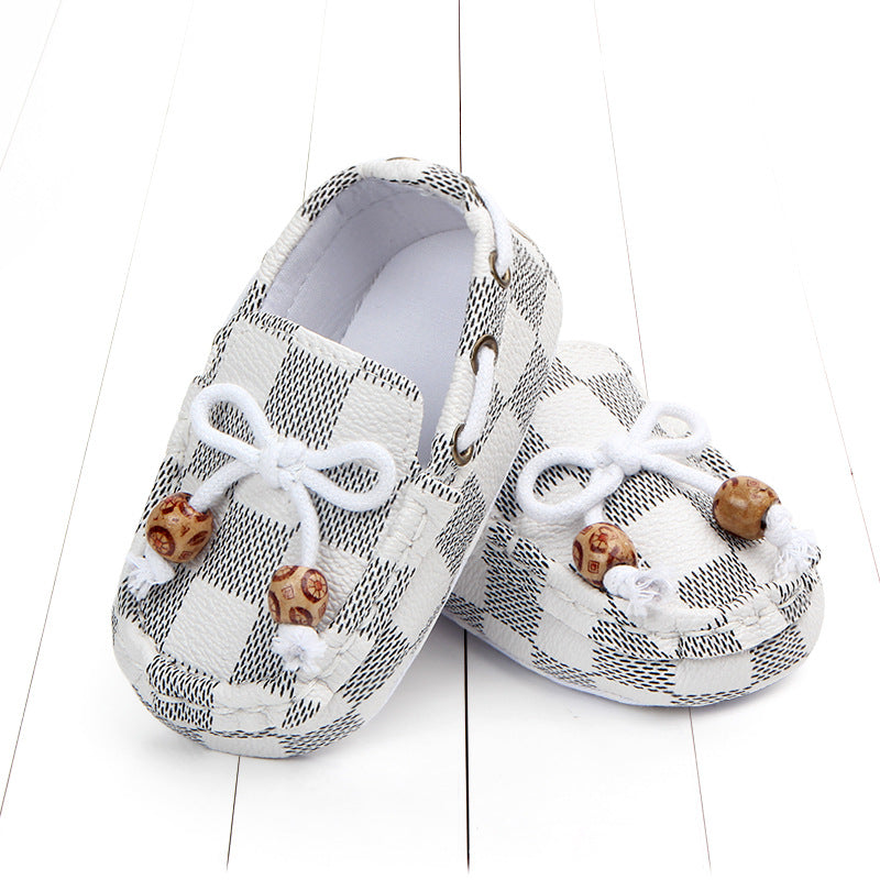 Paar wit geruite mocassins, met een veter en twee decoratieve parels