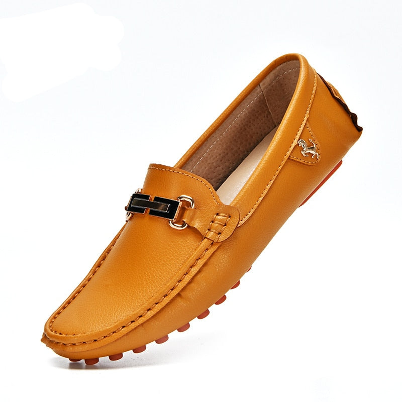 Camelkleurige loafer met gouden gesp in profiel op een witte achtergrond