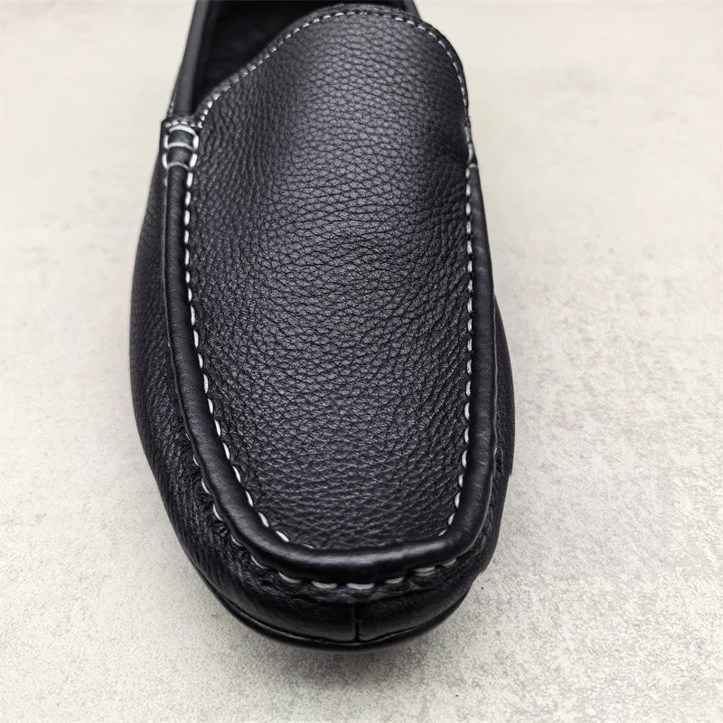 Zwarte instap mocassins voor heren met witte stiksels, schuin van boven