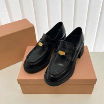 Zwarte loafers op een bruine schoenendoos