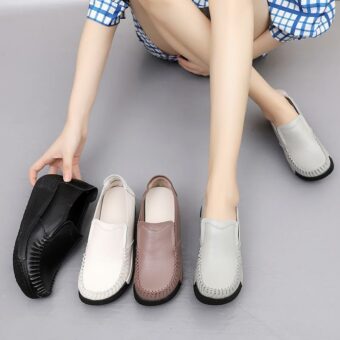 Been van een vrouw met grijze schoenen aan haar voeten en andere schoenen naast haar, zwart, wit en bruin