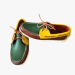Geelgroene en bruine loafers op een grijze bank
