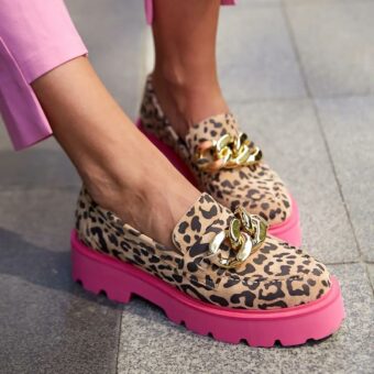 Voet van een vrouw met roze broek en luipaardschoenen met roze zolen