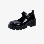 Un mocassin noir vernis avec des talons épais crantés et une bride sur le dessus.