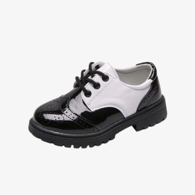Un mocassin fermé pour enfant, noir brillant avec une partie blanche