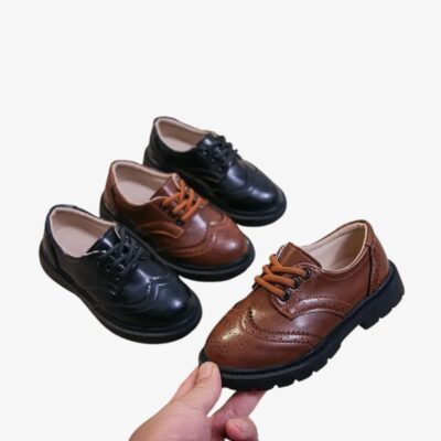 2 paires de mocassins noir et marron, dont une chaussure marron est tenue dans une main.