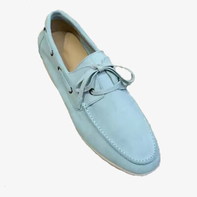 Een elegante bootsloafer van lichtblauw suède op een witte achtergrond