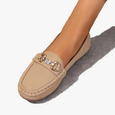 Beige loafers van imitatieleer met ketting en strass-vlinder op een witte achtergrond