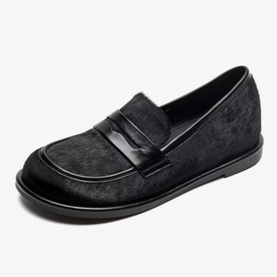 Een zwarte loafer van leer en paardenhaar op een witte achtergrond