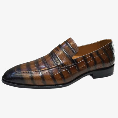Een Italiaanse herenloafer van leer met krokodillenprint op een effen witte achtergrond